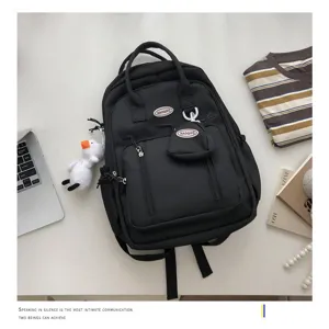 Vista detallada de mochila negra minimalista con gran capacidad y bolsillos frontales.
