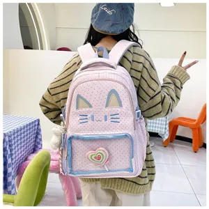 Dettaglio zaino gatto kawaii con tasca frontale trasparente e tessuto rosa a pois morbido.