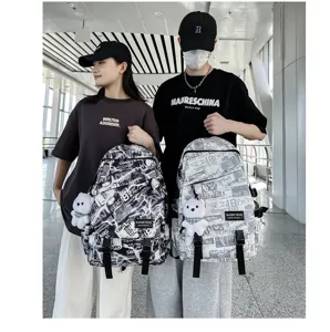 Trendy graffiti backpack for men and women, casual student school bag with cute bear pendant.