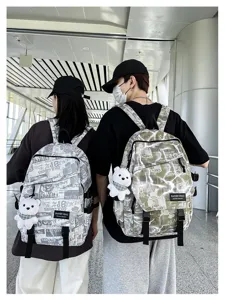 Detailed shot of stylish graffiti backpack with cute bear pendant for students and use.