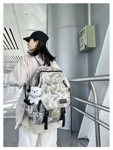 Trendy graffiti canvas backpack with bear pendant, large capacity school bag for students.
