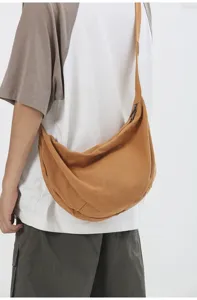 Detalle cercano del bolso bandolera de lona casual mostrando su textura de tela y diseño.