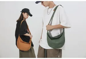 Detalle de bolso bandolera de lona con gran capacidad para uso diario estilo casual.