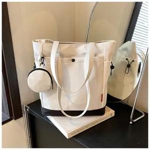 Detail view of large capacity canvas tote bag in white and black with attached coin purse.