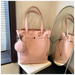 Detailed view of the pink canvas tote bag showing the side pocket and attached coin pouch.