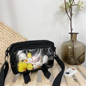 Black canvas crossbody bag with clear window and cute plush toys, stylish casual shoulder bag.