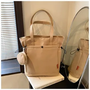 Large capacity beige tote bag detail view, featuring dual shoulder straps and a cute round coin purse.
