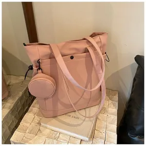 Detail view of large capacity pink tote bag with coin pouch and comfortable dual handles.
