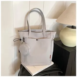 Detailed view of large capacity light grey tote bag with cute coin purse and side drawstrings.