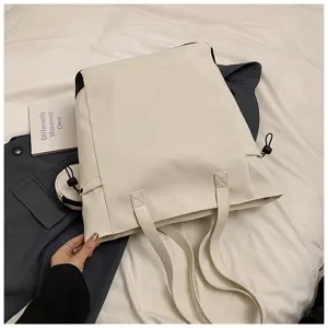 Close-up detail of the off-white large capacity tote bag featuring dual straps and side cords.