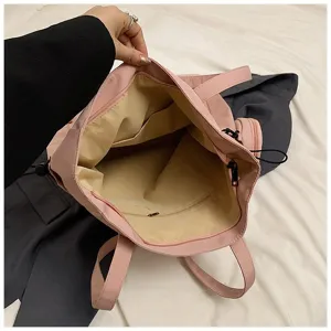 Interior view of the pink canvas tote bag showing spacious compartments and zipper pockets.