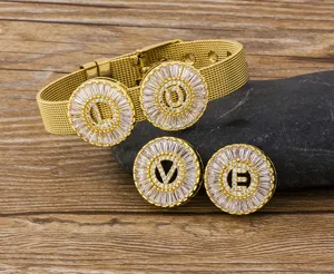 Close-up detail of the gold-plated mesh bracelet with sparkling crystal letter charms.