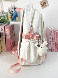 Vista dettagliata dello zaino scolastico bianco a pois rosa con tasca laterale e ciondolo.