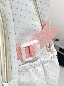Vista dettagliata dello zaino scolastico rosa a pois con cinturino regolabile e fibbia.
