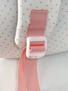 Vista dettagliata della tracolla dello zaino rosa a pois con fibbia regolabile per uso quotidiano.