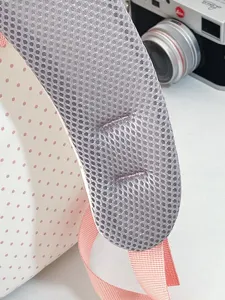 Dettaglio dello zaino carino con spallacci in rete traspirante e design a pois rosa.