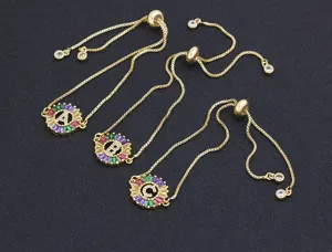 Detailed shot of gold-plated adjustable alphabet bracelets featuring colorful zircon round pendants.