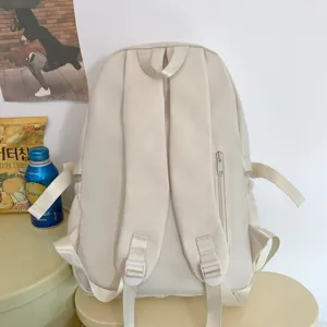 Primo piano del retro di uno zaino casual beige, che mostra le cinghie e la cerniera.