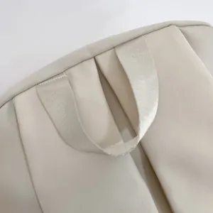 Vista dettaglio zaino con manico rinforzato e cuciture robuste, stile minimalista.