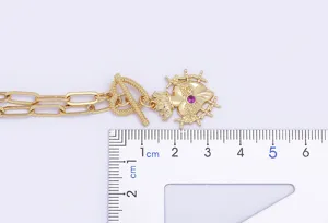 Dettaglio della collana con ciondolo a cuore sacro in stile punk dorato con righello.