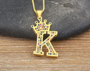 Close-up detail of the colorful zircon crown letter K pendant necklace on textured wood.
