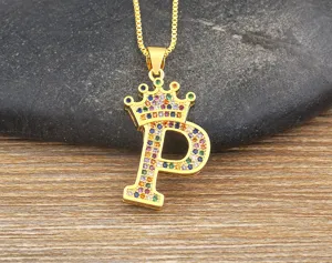 Close-up detail of letter P crown pendant necklace with colorful cubic zirconia stones sparkling.