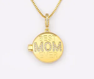 Primer plano de un collar de medallón chapado en oro grabado con Best Mom Ever y circonitas.