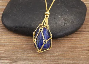 Close-up detail of the metal cage crystal pendant necklace resting on a natural dark stone.