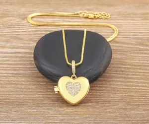 Exquisito detalle de collar con colgante de medallón de corazón dorado, circonitas brillantes.