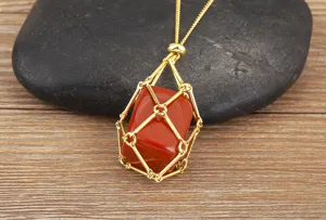 Detail shot of a gold-plated metal cage pendant necklace holding a natural red crystal stone.