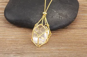 Close-up of a gold-plated wire cage pendant necklace featuring a clear natural crystal stone.