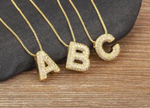 Detailed close-up of gold micro-pave cubic zirconia letter pendant necklaces A, B, and C.