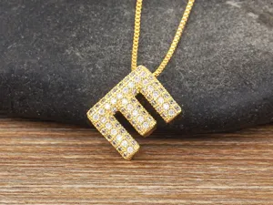 Detailed close-up of gold-plated letter E pendant necklace with sparkling micro pave cubic zirconia.