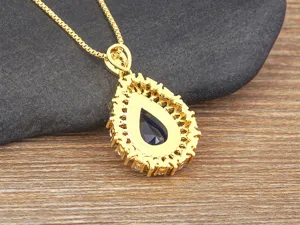 Squisita collana con ciondolo in pietra preziosa blu a goccia con design luminoso.