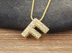 Detailed view of gold letter F pendant necklace, micro-paved zirconia cubic stones on copper chain.