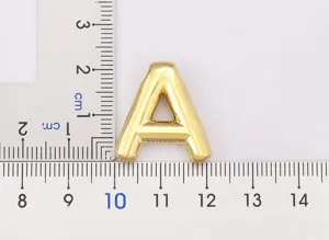 Close-up detail of smooth gold-plated bubble letter A pendant with measurement scale.