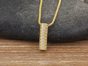 Gold paved cubic zirconia cylinder pendant necklace close up jewelry detail display shot
