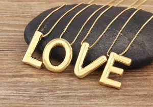Detailed view of the 18k gold plated bubble letter Love necklace pendant showcase.