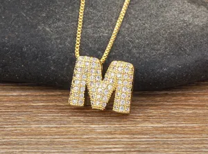 Detail view of gold letter M pendant necklace with micro pave cubic zirconia stones.