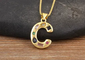 Gold plated letter C pendant necklace with colorful cubic zirconia details close up.