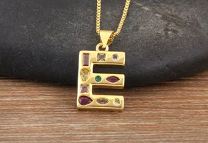 Close-up of gold-plated letter E pendant necklace inlaid with vibrant colorful cubic zirconia.