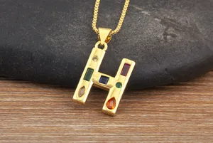 Detailed view of gold plated letter H pendant necklace with colorful cubic zirconia.
