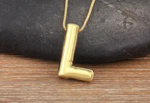 Detail view of a glossy gold puff letter L pendant necklace, chic and minimalist style.