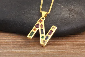 Close-up detail of gold plated letter N pendant inlaid with colorful sparkling cubic zirconia.