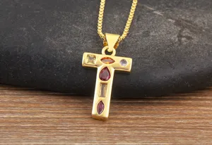 Close-up detail of a gold-plated alphabet T pendant necklace with colorful cubic zirconia.
