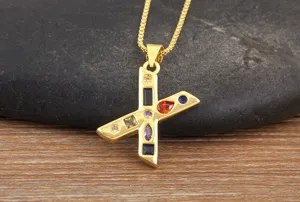 Detailed view of gold-plated letter X pendant necklace with colorful sparkling cubic zirconia stones.