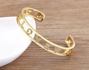 Detailansicht des goldenen Armreifens mit LOVE-Buchstaben und funkelnden Zirkonsteinen.