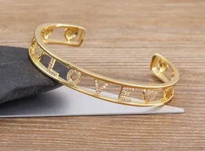 Detailansicht des vergoldeten LOVE Armreifs mit funkelnden Zirkonia und Herz-Ausschnitt.
