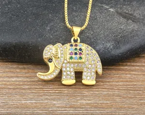 Primer plano detallado de un collar con colgante de elefante chapado en oro con piedras.
