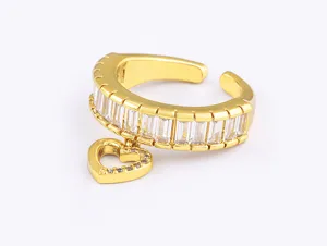 Vergoldeter offener Ring mit Baguette-Zirkonia und einem charmanten Herz-Anhänger.